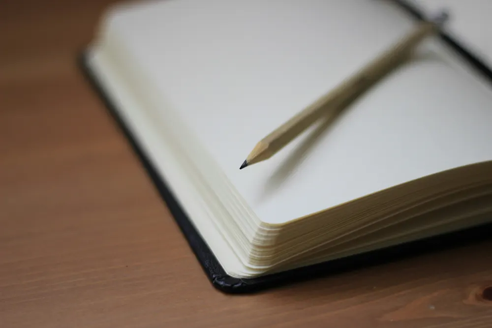 Ein Bleistift liegt auf einem aufgeschlagenen Notizbuch