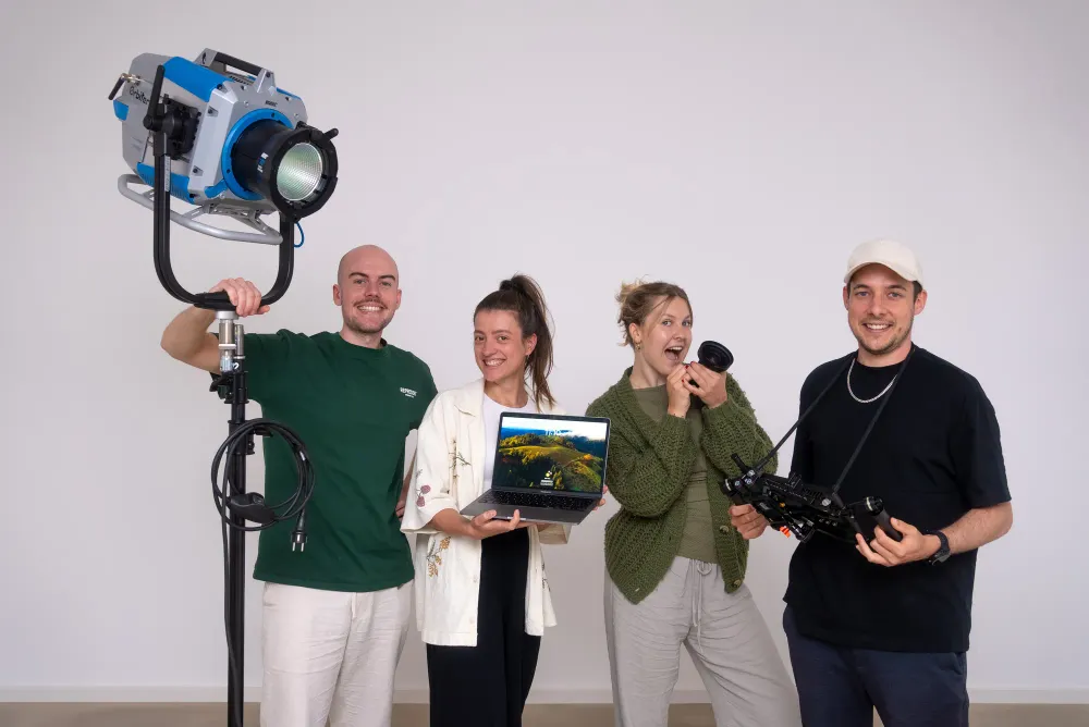 Vier Personen aus dem 022-Team im Studio mit Scheinwerfer, Laptop, Objektiv und Kamera