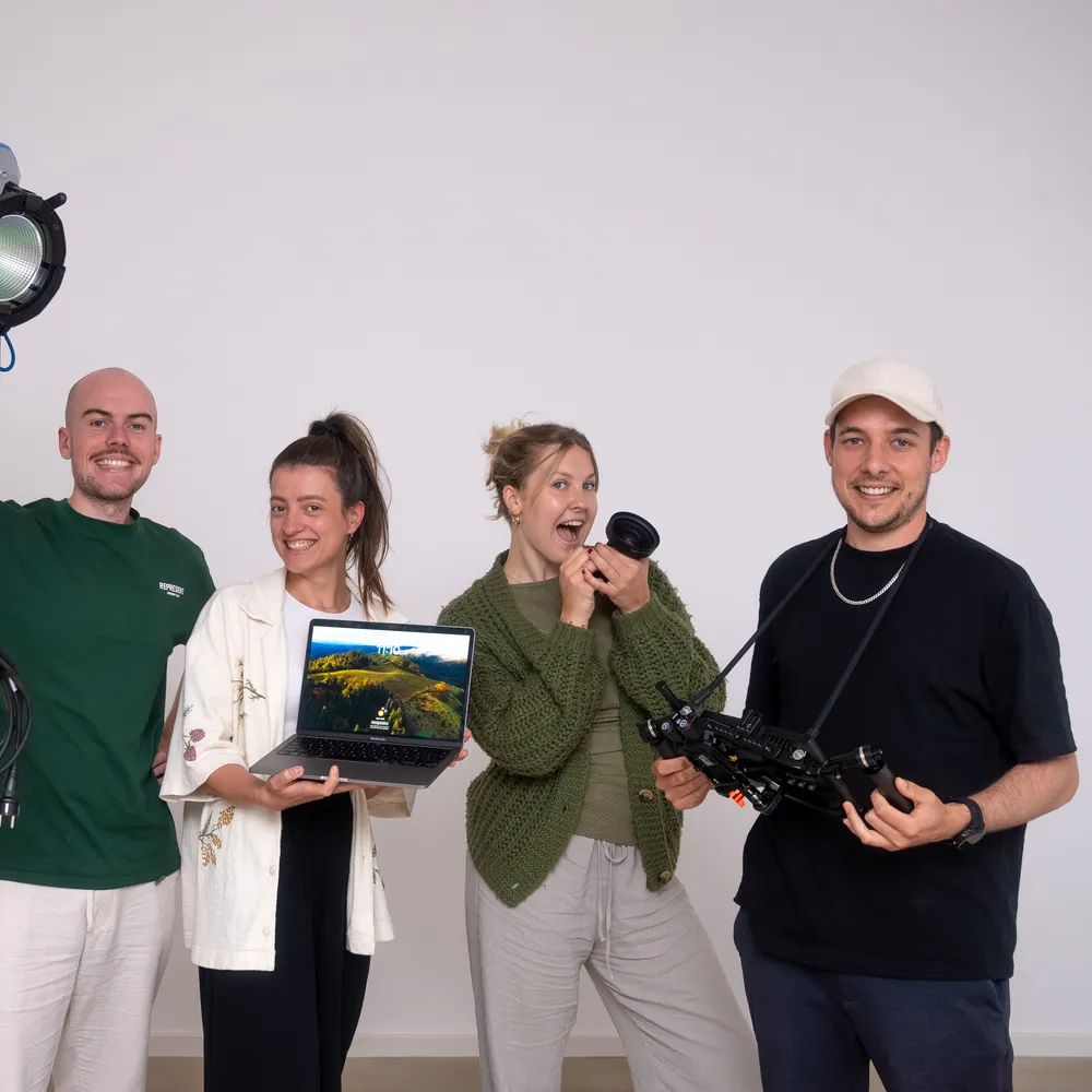 Vier Personen aus dem 022-Team im Studio mit Scheinwerfer, Laptop, Objektiv und Kamera